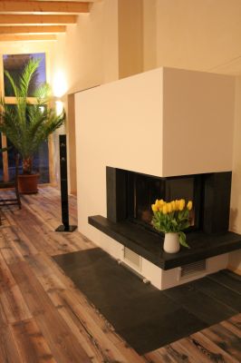 Abbildung: Wohnzimmer mit massivem Kamin und hochwertigem Parkett