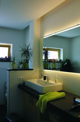 Abbildung: Ein Badezimmer mit Waschtischkonsole aus Naturstein und beleuchtetem Spiegel