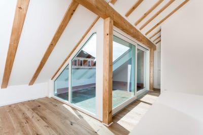Abbildung: sichtbare Balken und viel Licht im Dachgeschoss