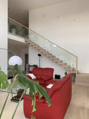 Abbildung: eine Faltwerktreppe mit Ganzglasgeländer führt zur Galerie