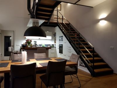 Abbildung: eine Stahltreppe mit Holzstufen, die Küche passt perfekt darunter